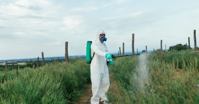 Worker in hazmat suit spraying chemicals