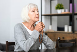 Senior woman praying rosary