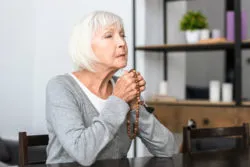 Senior woman praying rosary