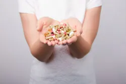 A woman holds supplements in her hands.