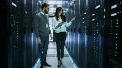 Two technicians work on internet equipment.