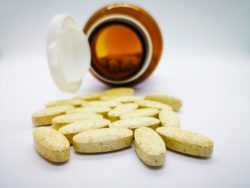 Yellow vitamins spilling from jar