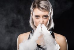 woman using JUUL vape pen
