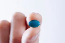 Young man with a blue pill