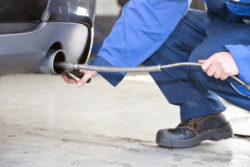 A man checks a vehicle's emissions.