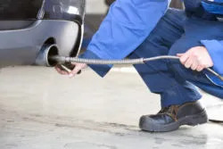 A man checks a vehicle's emissions.