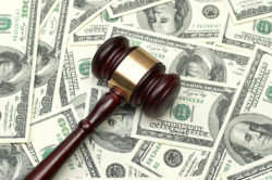 A gavel rests on a pile of cash.