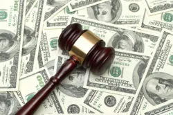 A gavel rests on a pile of cash.