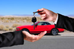 One person hands car keys to another.