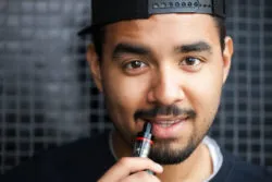 A man uses an e-cigarette.