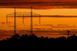 Sunset behind a power line tower
