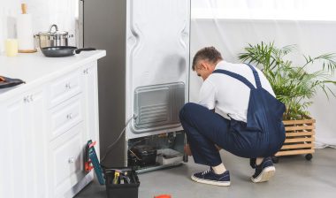 repairman fixing refrigerator