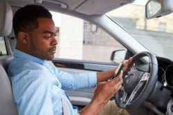 A rideshare driver checks his smartphone.