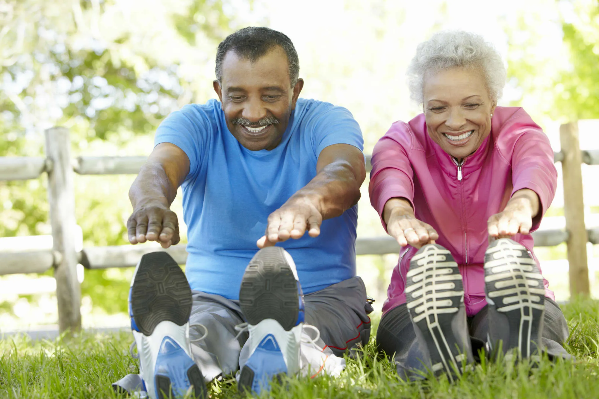 Senior couple stretching, touching toes