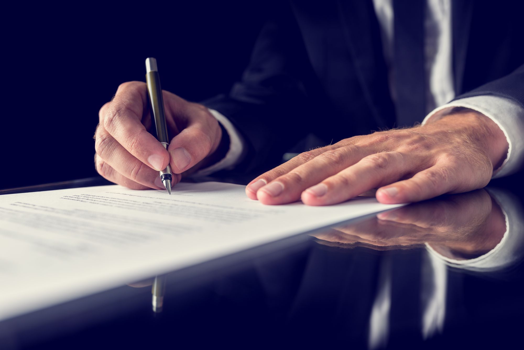 Two hands signing a document