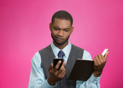 A man looks at his phone suspiciously.