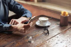 A woman texts at a coffee shop.