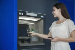 A woman uses an ATM.