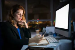 A woman works in an office at night.