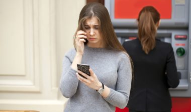 A concerned woman steps away from an ATM.