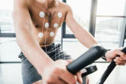 A man takes a cardiac stress test on a stationary bike.