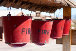 Fire buckets hang under a shelter.