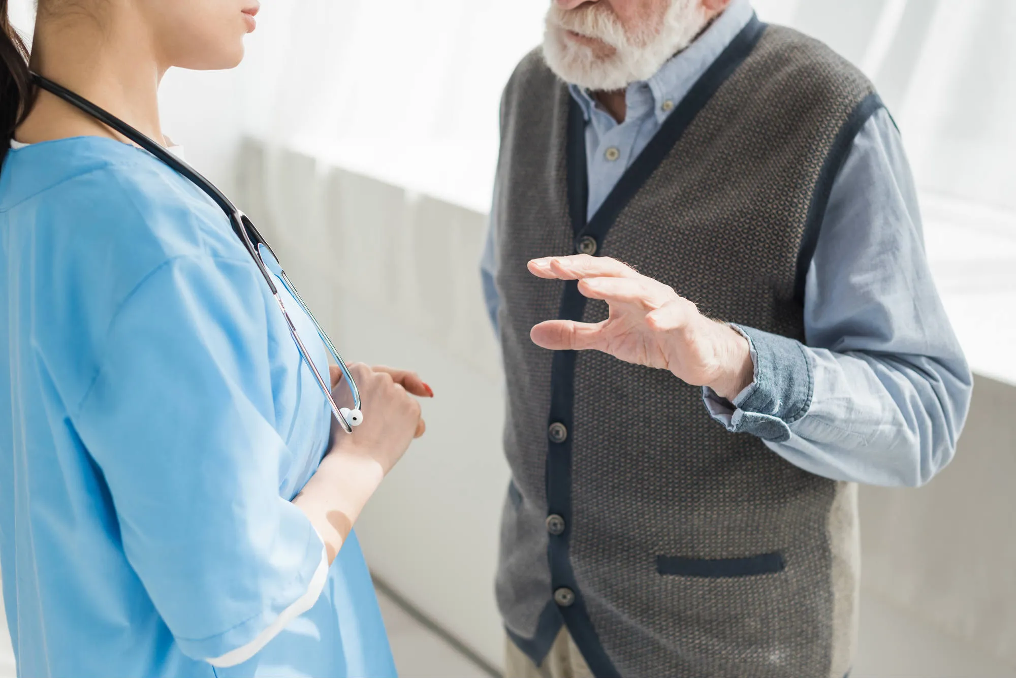 Man gesturing while talking to nurse