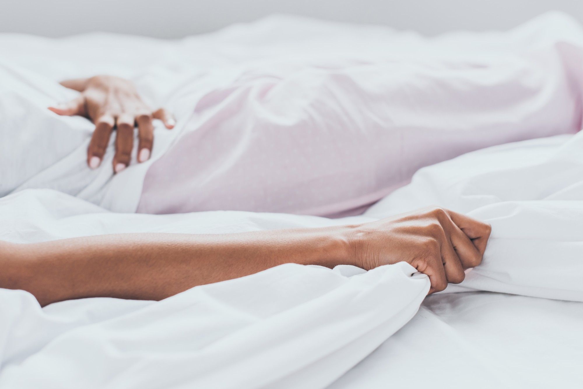 woman experiencing abdominal pain on a bed