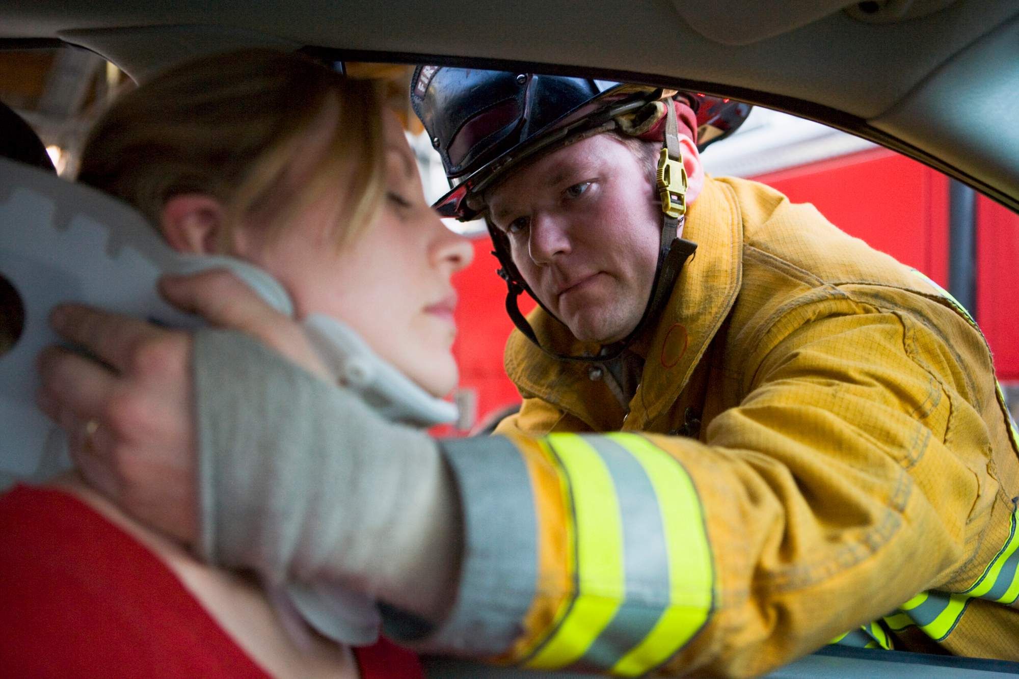 Firefighters helping an injured woman in a car