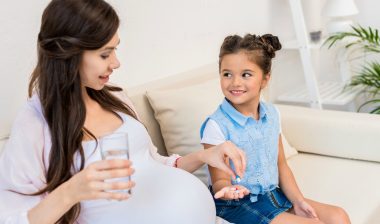 Child handing pregnant mother pills