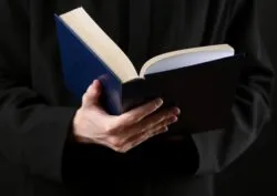 priest hands holding a bible