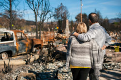 A couple surveys damage after a fire.