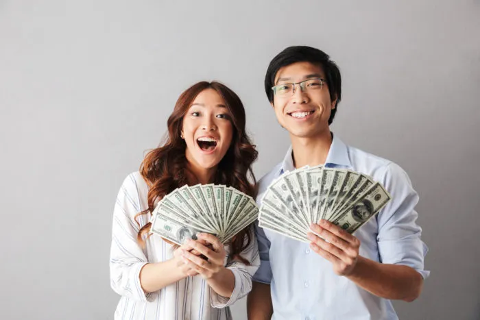 couple holding money from the ADT class action settlement