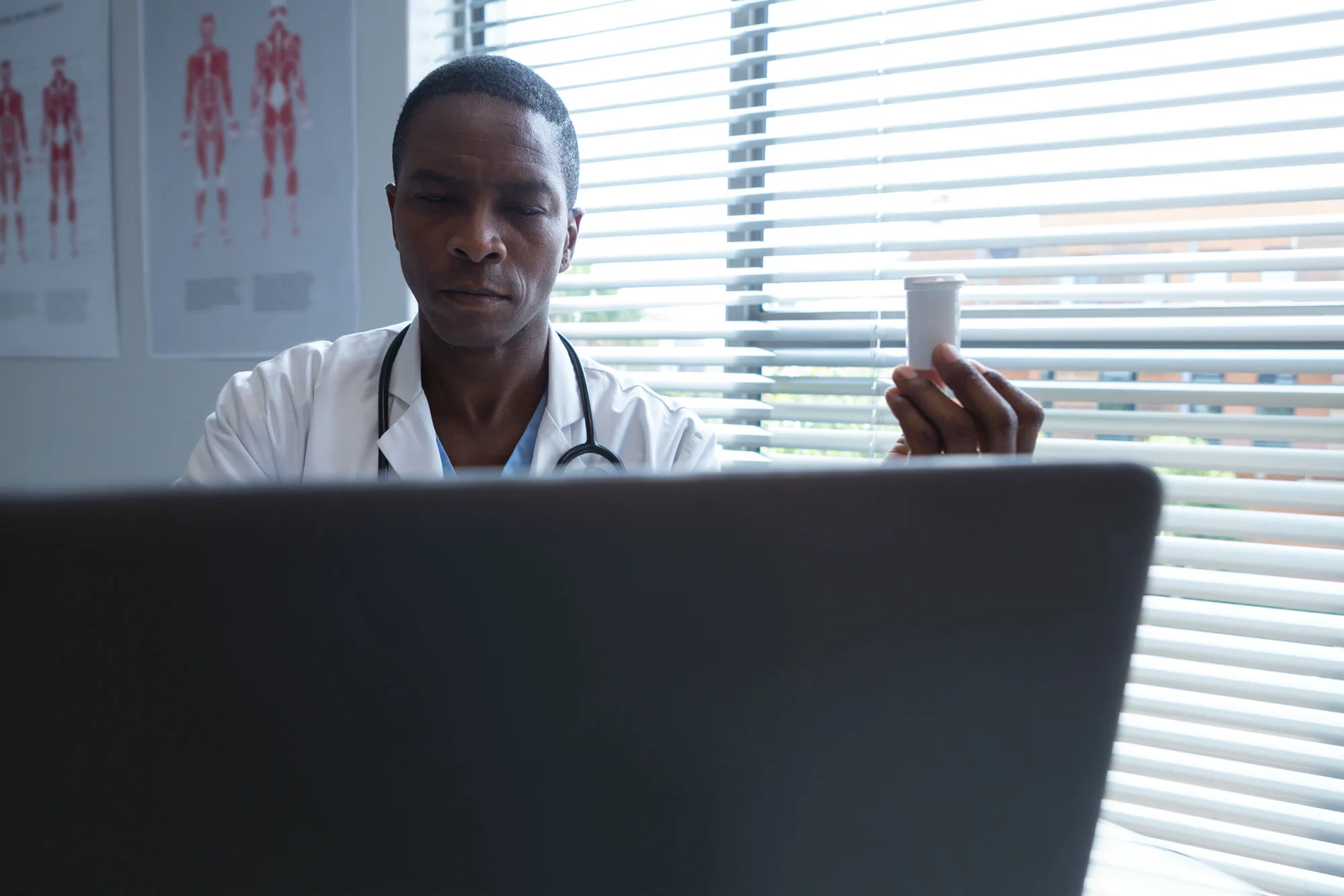 Doctor holding pill bottle researching