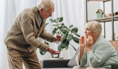 Elderly husband offering wife medication
