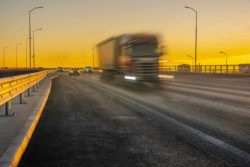 Semi-truck driving at sunset