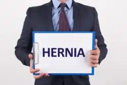 Man holds paper that says hernia