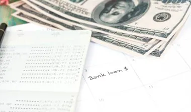 Bank loan in calendar with cash and a ledger