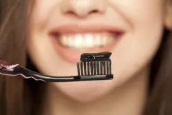 Black charcoal toothpaste on a toothbrush
