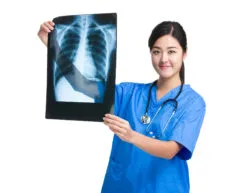 A doctor holds up a chest X-ray.