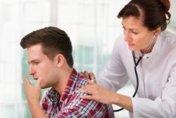 doctor checking lung health of teenage male