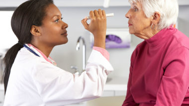 An eye doctor examines a woman's eyes.