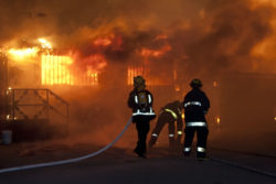 Firemen try to put out a burning house.