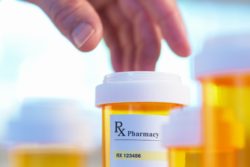 hand picking up pill bottle