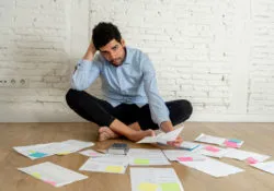 A man looks over paperwork in an empty room.