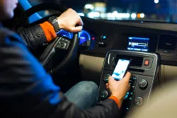 A rideshare driver checks his cellphone.