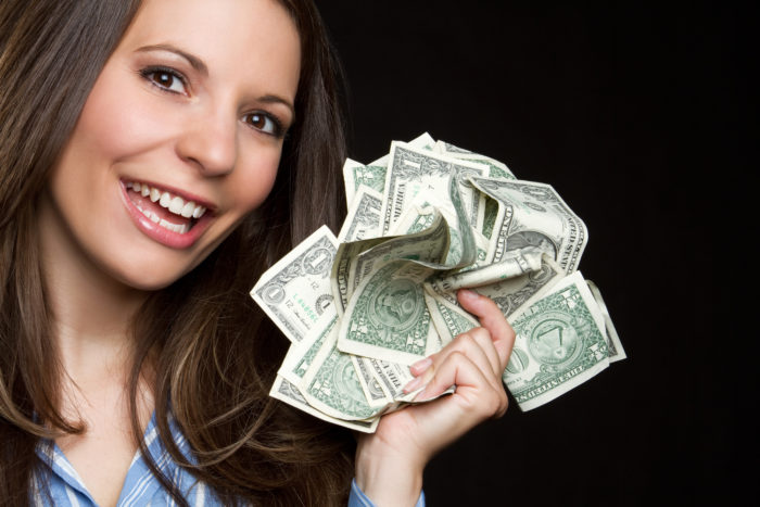 woman holding settlement money from class action rebates