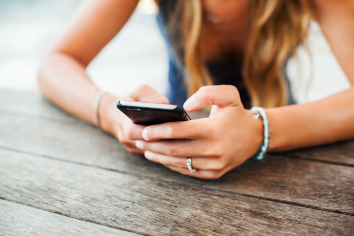 girl getting text from sunrise detox
