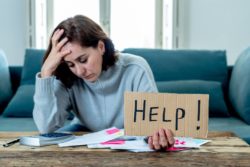 Woman with help sign and bills