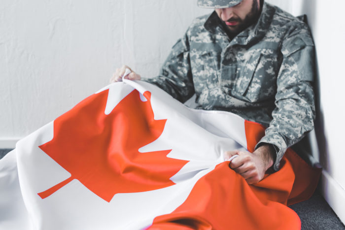 canadian military member holding flag